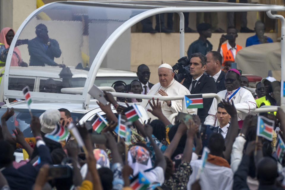 Pope Francis waves as he tours the audience in his vehicle after arriving for a Holy Mass at the John Garang Mausoleum in Juba, South Sudan Sunday, Feb. 5, 2023. Pope Francis is in South Sudan on the final day of a six-day trip that started in Congo, hoping to bring comfort and encouragement to two countries that have been riven by poverty, conflicts and what he calls a "colonialist mentality" that has exploited Africa for centuries. (AP Photo/Ben Curtis)