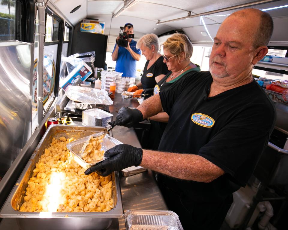 Jay Cowart, right, serves up macaroni and cheese outside AdventHealth Ocala hospital on June 9.