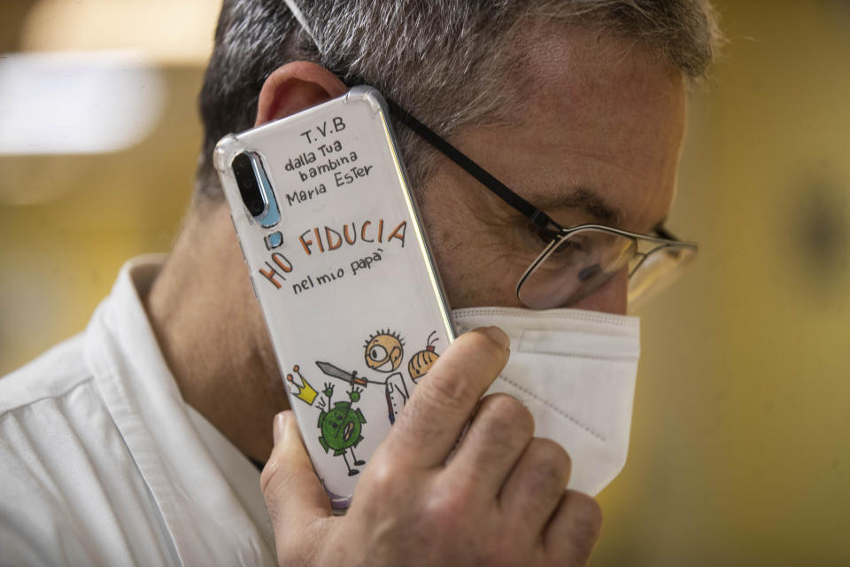 Dr. Gabriele Zanolini director of the main covid ward at Mellino Mellini hospital talks on his smartphone in the emergency COVID-19 in Chiari, northern Italy, Monday, March 8, 2021. The 160-bed hospital in the Po River Valley town of Chiari has no more beds for patients stricken with the highly contagious variant of COVID-19 first identified in Britain, and which now has put hospitals in Italy’s northern Brescia province on high alert. Italian on the doctor's phone reads: 'I love you, from your little girl Marina Ester. I trust my dad. (AP Photo/Luca Bruno)