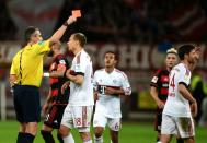 Referee Knut Kircher shows the red card to Bayern Munich's midfielder Xabi Alonso (R) during the German first division Bundesliga football match in Leverkusen, western Germany, on February 6, 2016