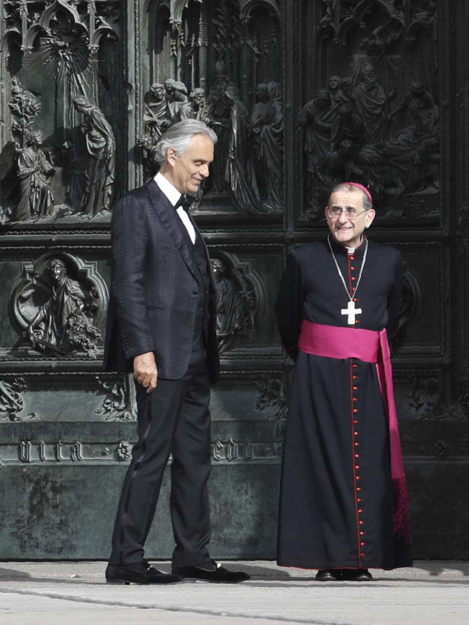 FILE - In this Sunday, April 12, 2020, Italian singer Andrea Bocelli stands next to Archbishop of Milan Mario Delpini prior to performing outside the Duomo cathedral, on Easter Sunday, in Milan, Italy. Italian tenor Andrea Bocelli, who had COVID-19, says the pandemic lockdown in his country made him feel “humiliated and offended” for depriving him of freedom. Bocelli spoke at a panel held on Monday in a Senate conference room, where he was introduced by right-wing opposition leader Matteo Salvini, who has railed against the government's stringent measures aimed at reining in the coronavirus outbreak. (AP Photo/Luca Bruno, File)