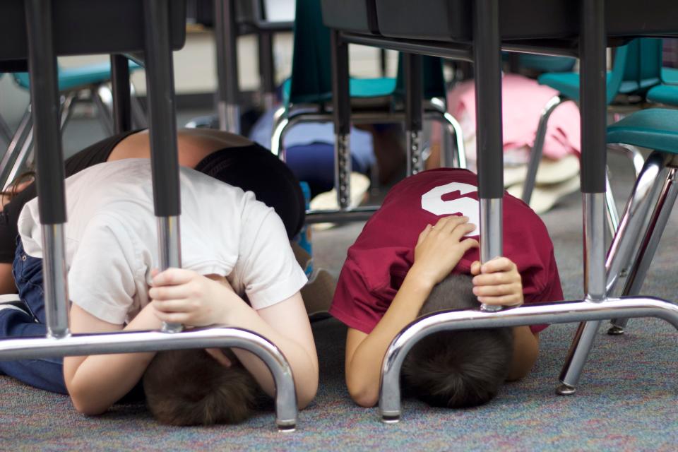 Students in Kate Wagoner's third-grade class practice drop, cover and hold on earthquake safety at McCornack Elementary School during the Great Oregon ShakeOut on Oct. 19 in Eugene.