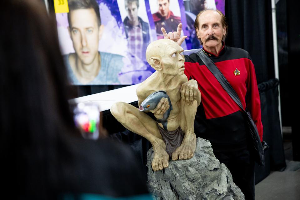 Gary L. Cox, of Sandy, poses with a statue of Gollum from “The Lord of the Rings” and “The Hobbit,” while his wife Laura Lea Cox takes a photo at the FanX convention at the Salt Palace in Salt Lake City on Thursday, Sept. 21, 2023. | Spenser Heaps, Deseret News