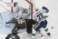 Vegas Golden Knights' William Karlsson (71) is stopped by Vancouver Canucks goalie Jacob Markstrom (25) as Alexander Edler (23) defends during the third period of Game 2 of an NHL hockey second-round playoff series, Tuesday, Aug. 25, 2020, in Edmonton, Alberta. (Jason Franson/The Canadian Press via AP)