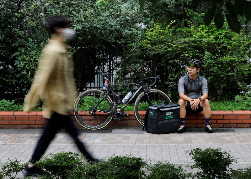 Takenobu Tonegawa pauses as he works his part-time job as Uber Eats delivery person amid the coronavirus disease (COVID-19) outbreak, in Tokyo