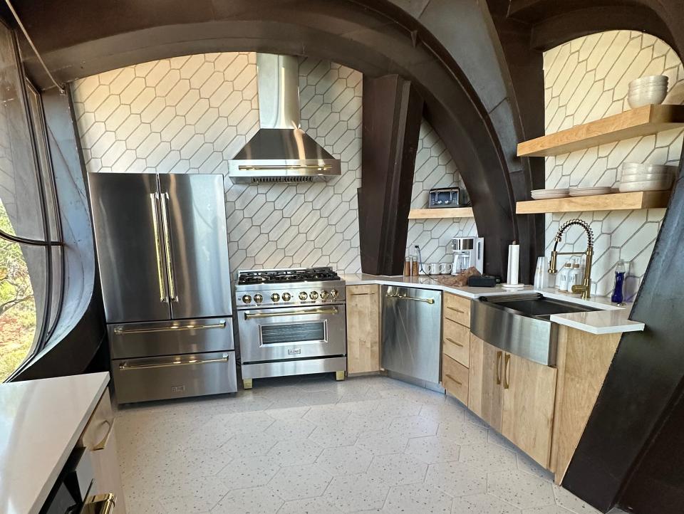 Archways on ceiling above a modern kitchen with a stainless-steel fridge and range