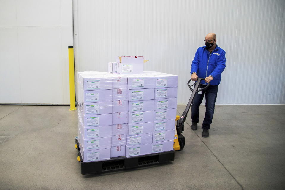 Michael Gray moves a pallet of some of the first 500,000 of the two million AstraZeneca COVID-19 vaccine doses that Canada has secured through a deal with the Serum Institute of India in partnership with Verity Pharma Wednesday, March 3, 2021, at a facility in Milton, Ontario. (Carlos Osorio/Pool Photo via AP)