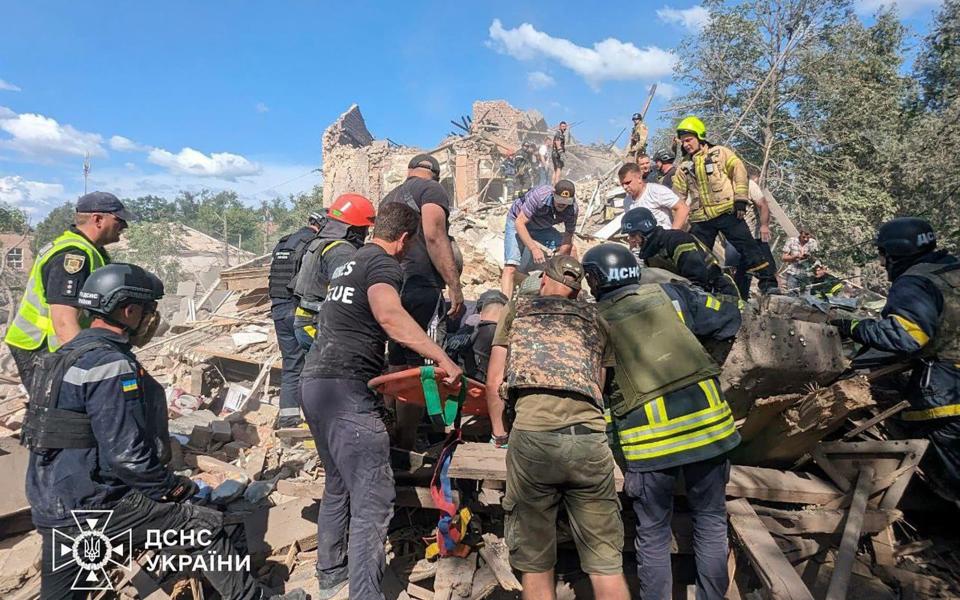 Emergency workers clear the rubble as they search for victims