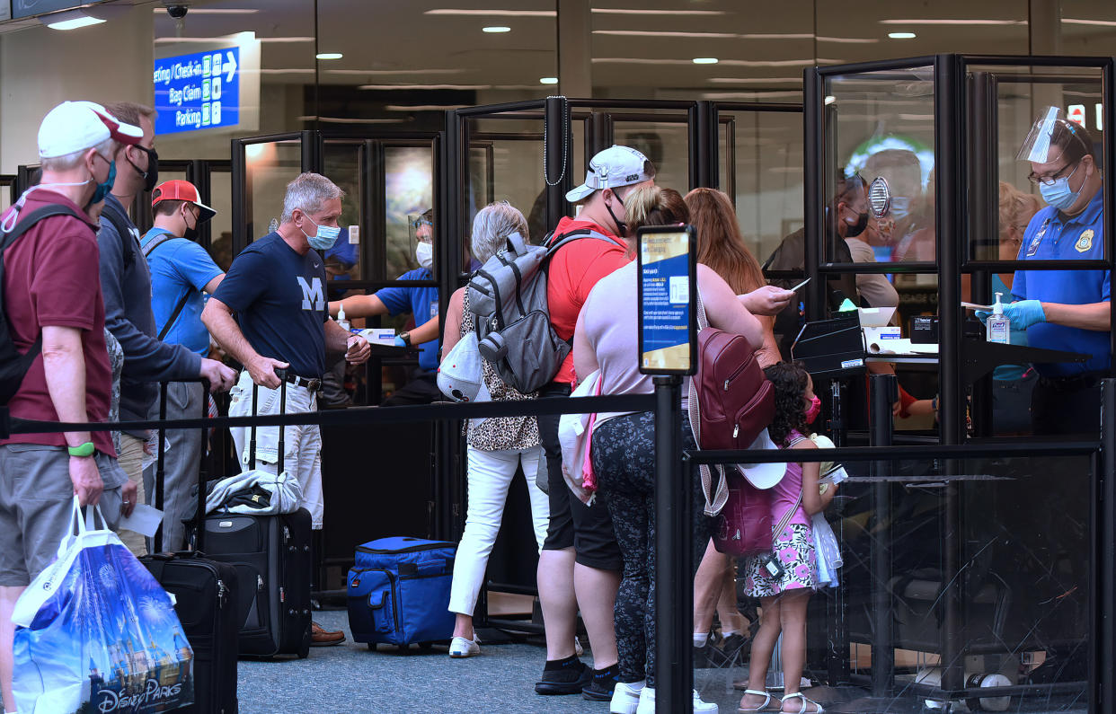 ORLANDO, FLORIDA, UNITED STATES - 2021/05/01: Travelers wearing face masks as a preventive measure against the spread of covid-19 wait in line to be screened by TSA at Orlando International Airport.
