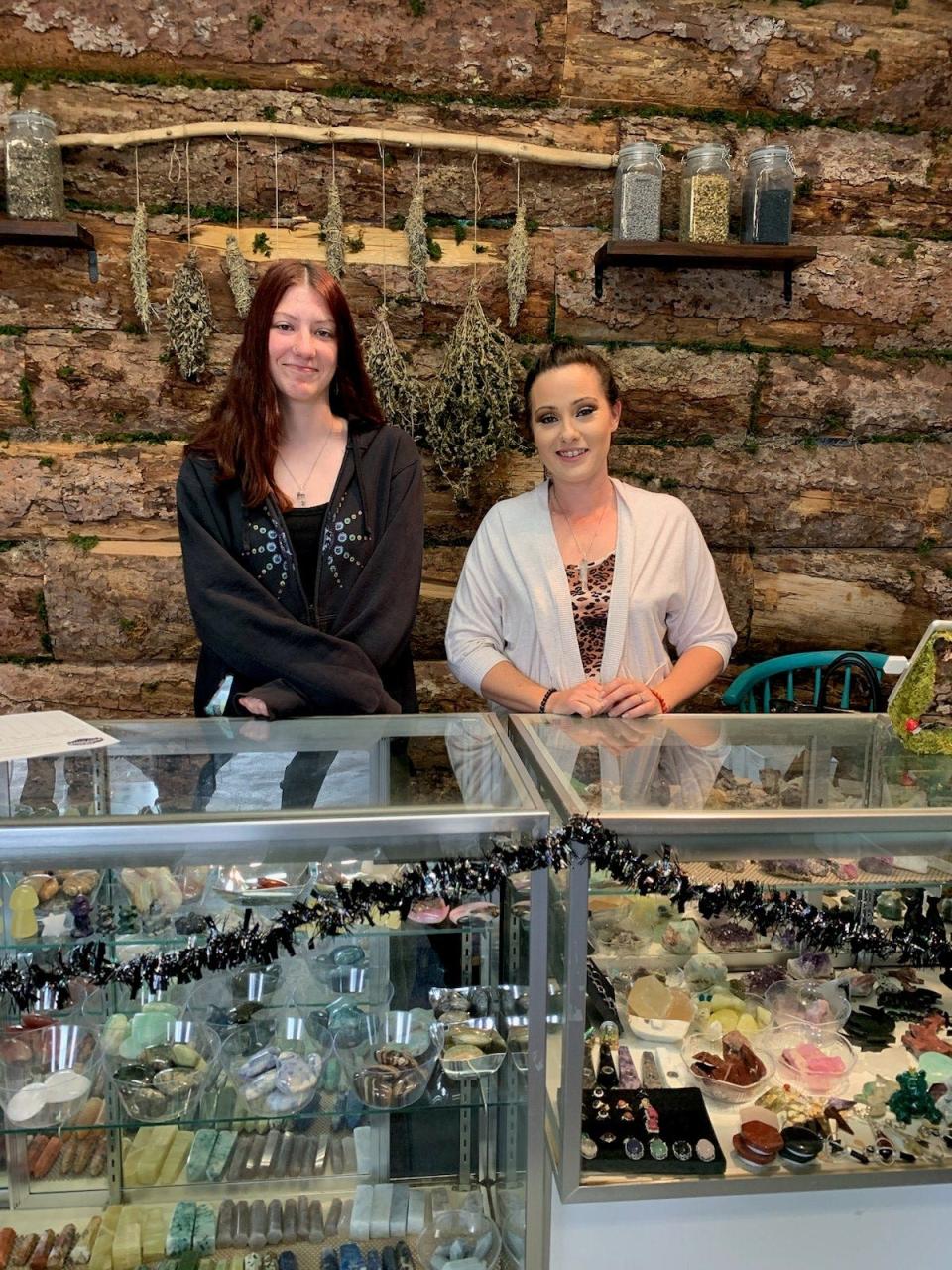 Vista Nueva High School freshman Suela Clearwater, left, stands behind a display case at Flora Vista's Mirror Mirror Spiritual Healing with her mentor, Vanessa Jackson.