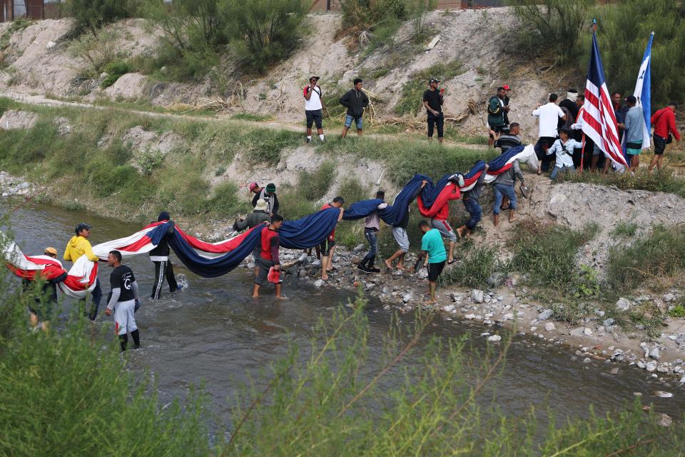 Migrantes venezolanos cruzan el río Bravo mientras protestan  contra las políticas de inmigración de Estados Unidos en Ciudad Juárez, México, el 31 de octubre de 2022.  (Foto de HERIKA MARTINEZ/AFP vía Getty Images)