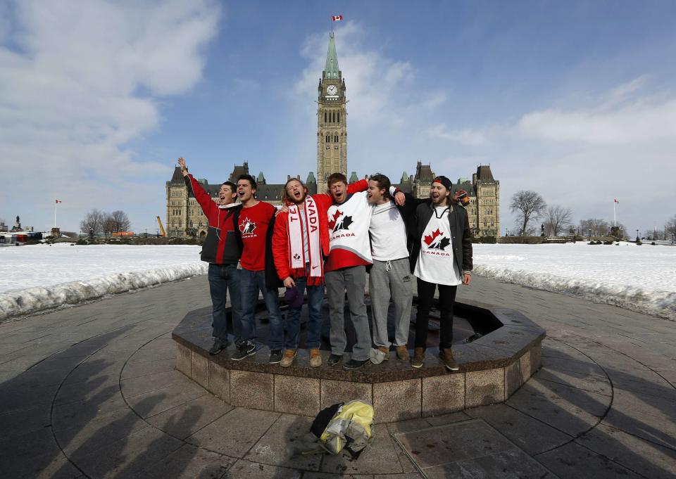 Fans sing the national anthem while celebrating Canada's gold medal win over Sweden in their men's ice hockey game at the Sochi 2014 Winter Olympic Games, on Parliament Hill in Ottawa February 23, 2014. REUTERS/Chris Wattie (CANADA - Tags: POLITICS SPORT ICE HOCKEY OLYMPICS)