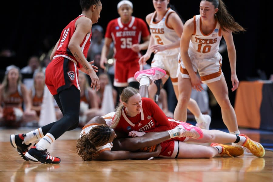 Texas forward Amina Muhammad, lower left, goes for the ball against North Carolina State forward Maddie Cox during the first half of an Elite Eight college basketball game in the women’s NCAA Tournament, Sunday, March 31, 2024, in Portland, Ore. (AP Photo/Howard Lao)