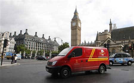 A Royal Mail passes the Houses of Parliament behind it, in central London, September 12, 2013. REUTERS/Eddie Keogh