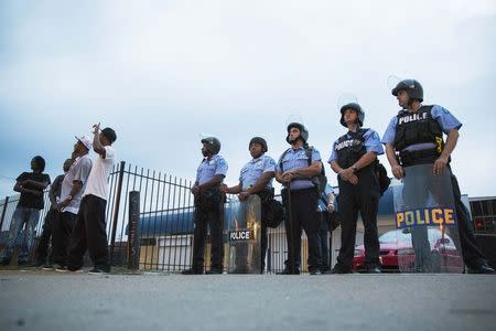 Protesters gesture and voice their opinions about police officers near Missouri Highway Patrol officers during ongoing demonstrations in reaction to the shooting of Michael Brown in Ferguson, Missouri August 16, 2014. REUTERS/Lucas Jackson