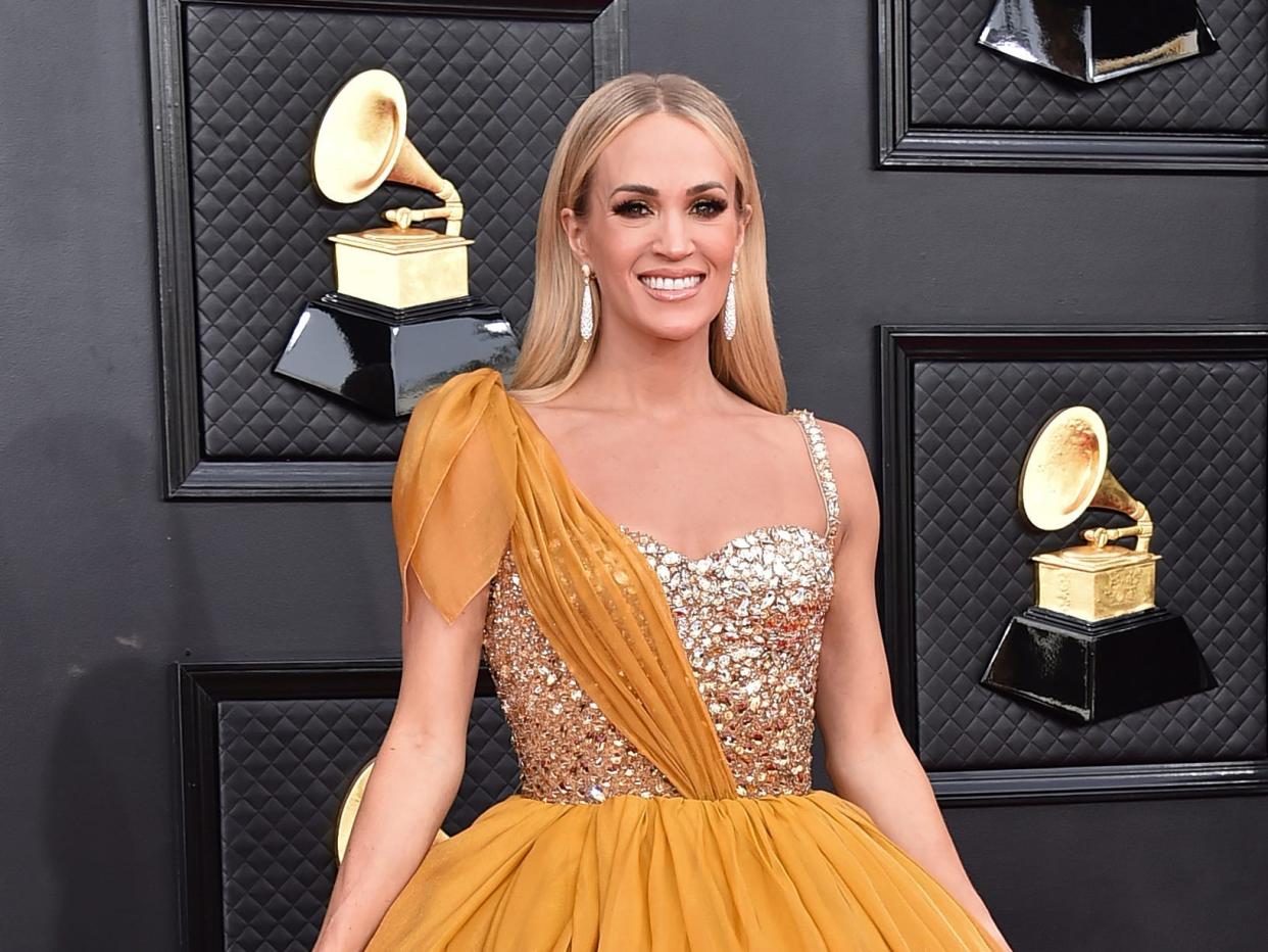 Carrie in a sparkly bodice dress with an orange sash and skit.