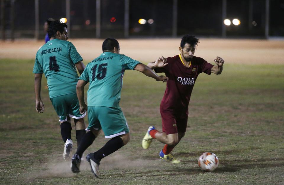 Players battle for control of the ball at a Maya Chapin soccer league game Wednesday, April 17, 2019, in Phoenix. (AP Photo/Ross D. Franklin)