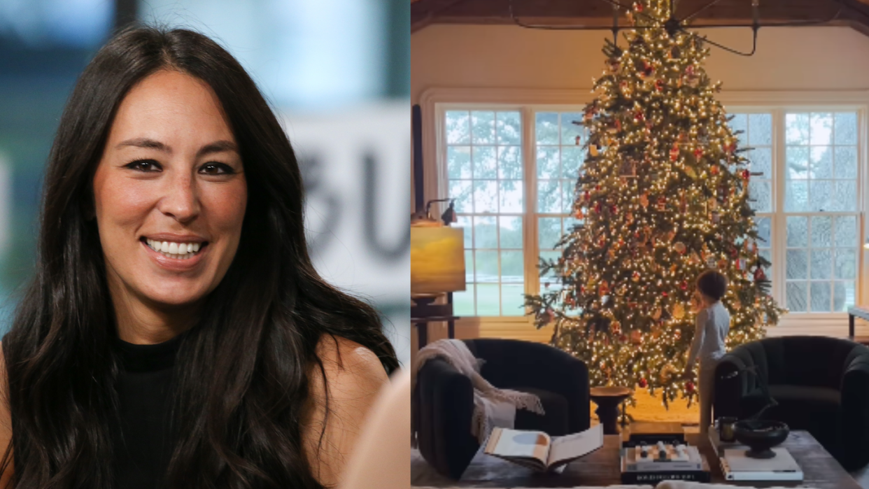 a woman smiling in front of a christmas tree