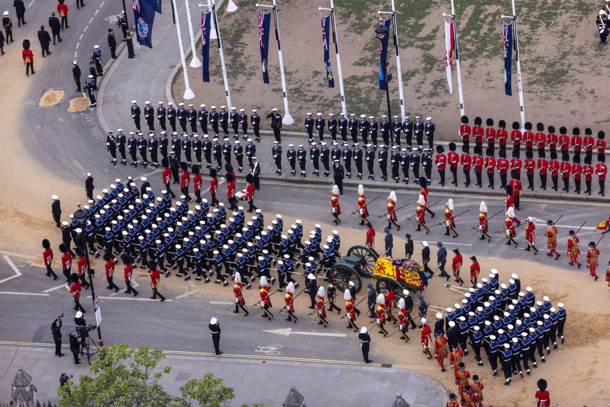 The proceedings in London with the Bearer Party, formed of personnel from The Queen's Company, 1st Battalion The Grenadier Guards, transfer Her Majesty's gun carriage on a road surface covered with sand. (Reuters)