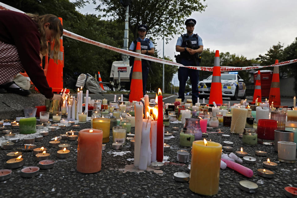 FILE - In this March 18, 2019, file photo, a student lights candle during a vigil to commemorate victims of March 15 shooting, outside the Al Noor mosque in Christchurch, New Zealand. New Zealanders are debating the limits of free speech after their chief censor banned a 74-page manifesto written by a man accused of massacring 50 people at two mosques. (AP Photo/Vincent Yu, File)