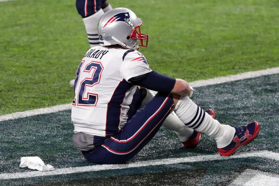 Tom Brady, sad while sitting on the field.