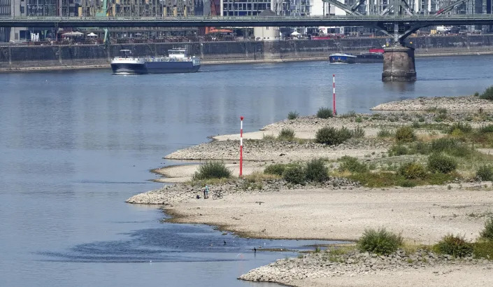 The river Rhine is pictured with low water in Cologne, Germany, Wednesday, Aug. 10, 2022. The low water levels are threatening Germany's industry as more and more ships are unable to traverse the key waterway. Severe drought will worsen in Europe in August as a hot and dry summer persists. (AP Photo/Martin Meissner)