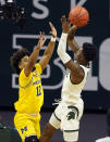 Michigan State guard Rocket Watts (2) shoots over Michigan guard Mike Smith (12) during the first half of an NCAA college basketball game, Sunday, March 7, 2021, in East Lansing, Mich. (AP Photo/Carlos Osorio)