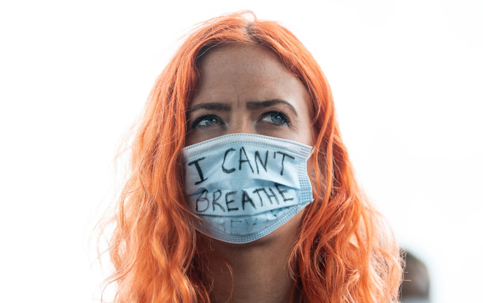 CARDIFF, UNITED KINGDOM - JUNE 06: A woman looks on while wearing a surgical mask which says "I can’t Breathe" during a Black Lives Matter protest at the Senedd on June 06, 2020 in Cardiff, United Kingdom. The death of an African-American man, George Floyd, while in the custody of Minneapolis police has sparked protests across the United States, as well as demonstrations of solidarity in many countries around the world. (Photo by Matthew Horwood/Getty Images)