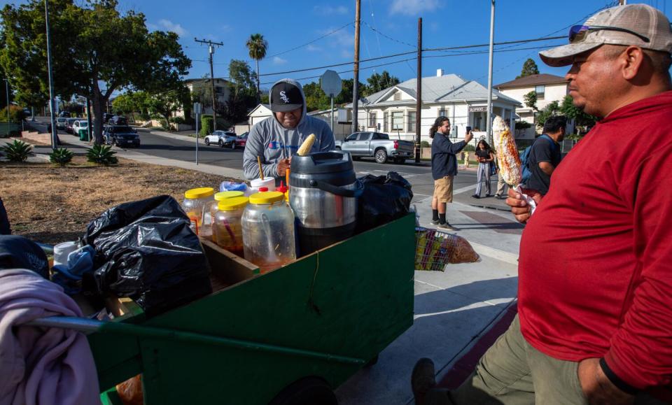 Angel, left, is a street vendor selling shaved ice and corn near Ortega Par