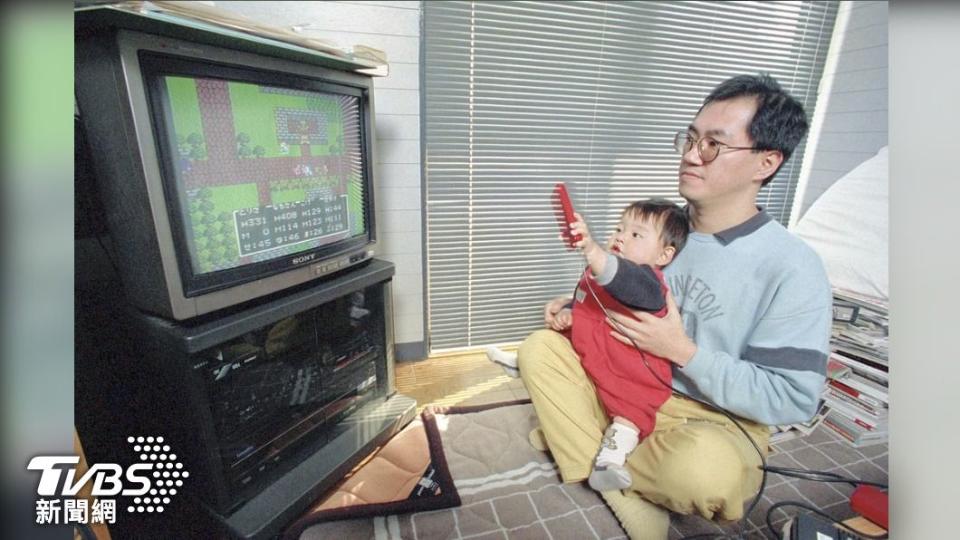 鳥山明於1988年在愛知縣與兒子遊玩任天堂紅白機。（圖／達志影像美聯社）