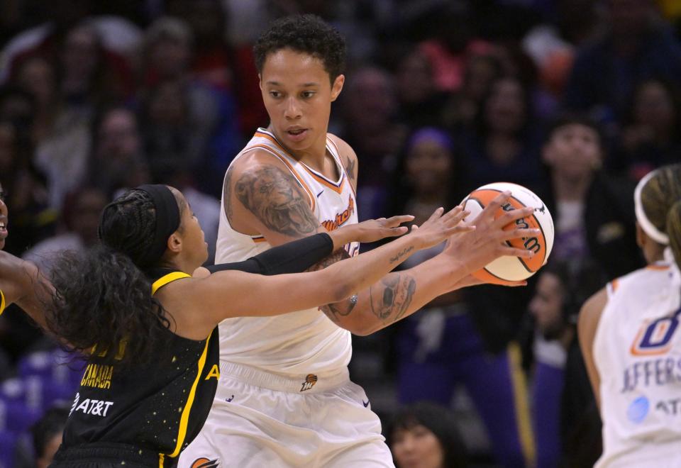 Phoenix Mercury center Brittney Griner keeps the ball out of the reach of Los Angeles Sparks guard Jordin Canada