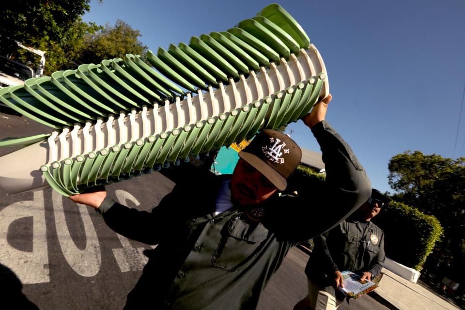 A man carries a stack of pails