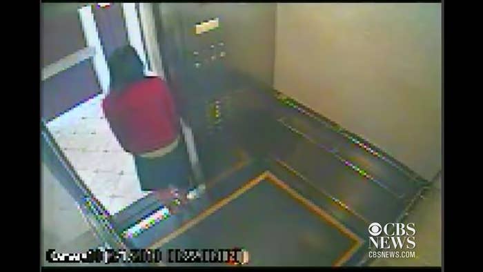 CCTV footage of Elisa in an elevator looking out the door