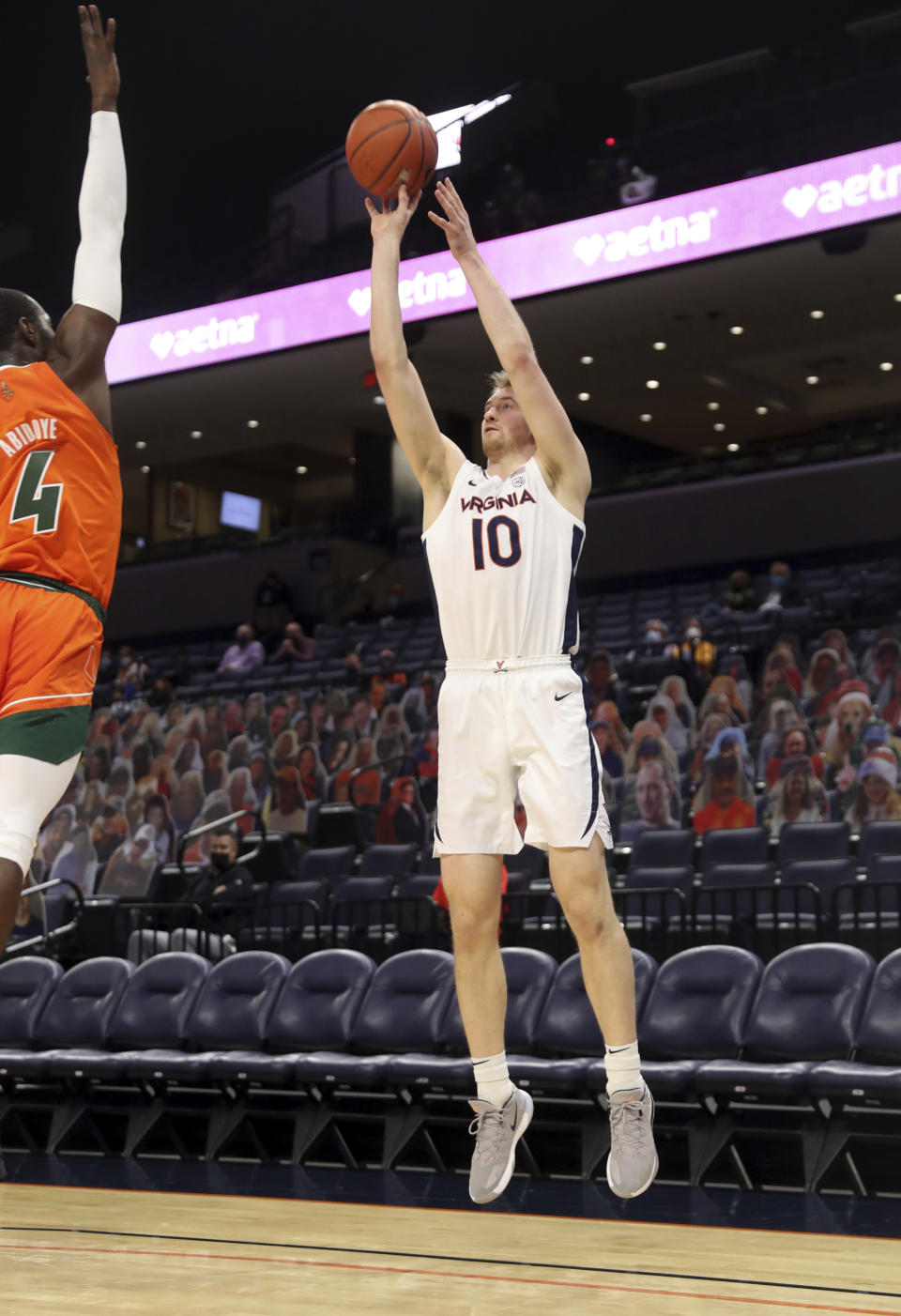 Virginia forward Sam Hauser (10) shoots over Miami guard Elijah Olaniyi (4) during an NCAA college basketball game Monday in Charlottesville, Va. (Andrew Shurtleff/The Daily Progress via AP, Pool)