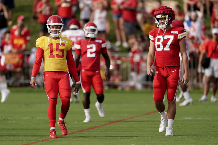Kansas City Chiefs quarterback Patrick Mahomes (15) and tight end Travis Kelce (87) warm up during NFL football training camp Sunday, Aug. 7, 2022, in St. Joseph, Mo. (AP Photo/Charlie Riedel)