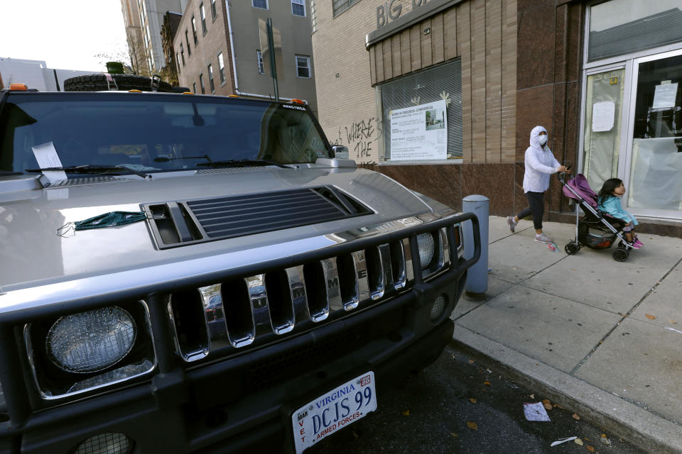 A parking violation envelope is affixed to the windshield of a Hummer vehicle parked near the Pennsylvania Convention Center where votes are being counted, Friday, Nov. 6, 2020, in Philadelphia. Police said Friday they arrested two men Thursday for not having permits to carry firearms near the center. Police said the men acknowledged that the Hummer spotted by officers near the center was was their vehicle. (AP Photo/Rebecca Blackwell)
