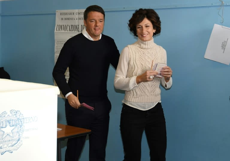 Italy's Prime Minister Matteo Renzi (L) and his wife Agnese Landini vote for a referendum on constitutional reforms, on December 4, 2016 at a polling station in Florence