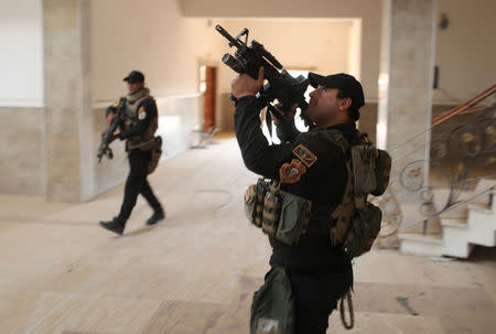 Iraqi special forces soldiers search a building located inside a church compound in Bartella, east of Mosul, Iraq October 21, 2016. REUTERS/Goran Tomasevic