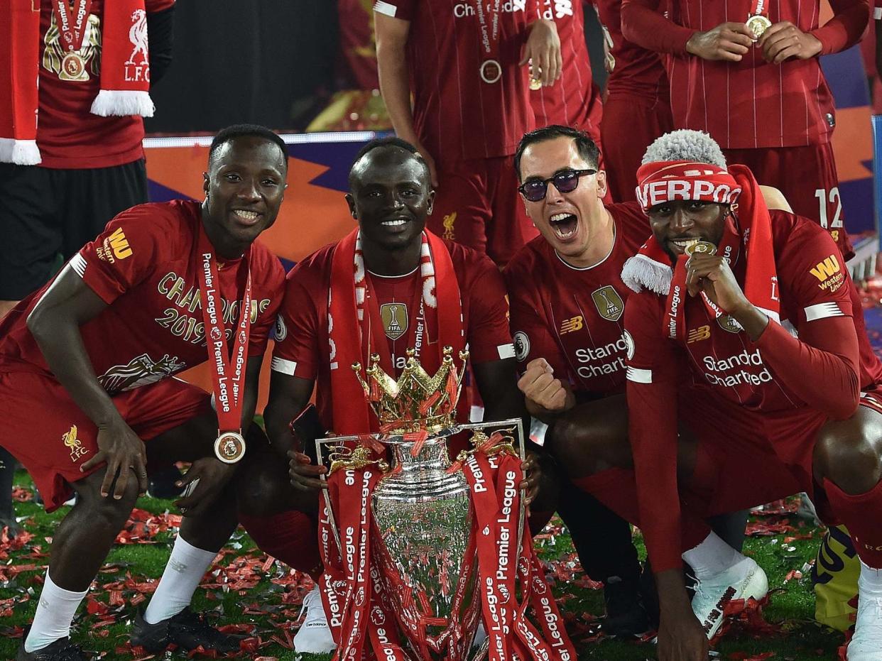 Divock Origi, right, celebrates with the Premier League trophy: Getty Images