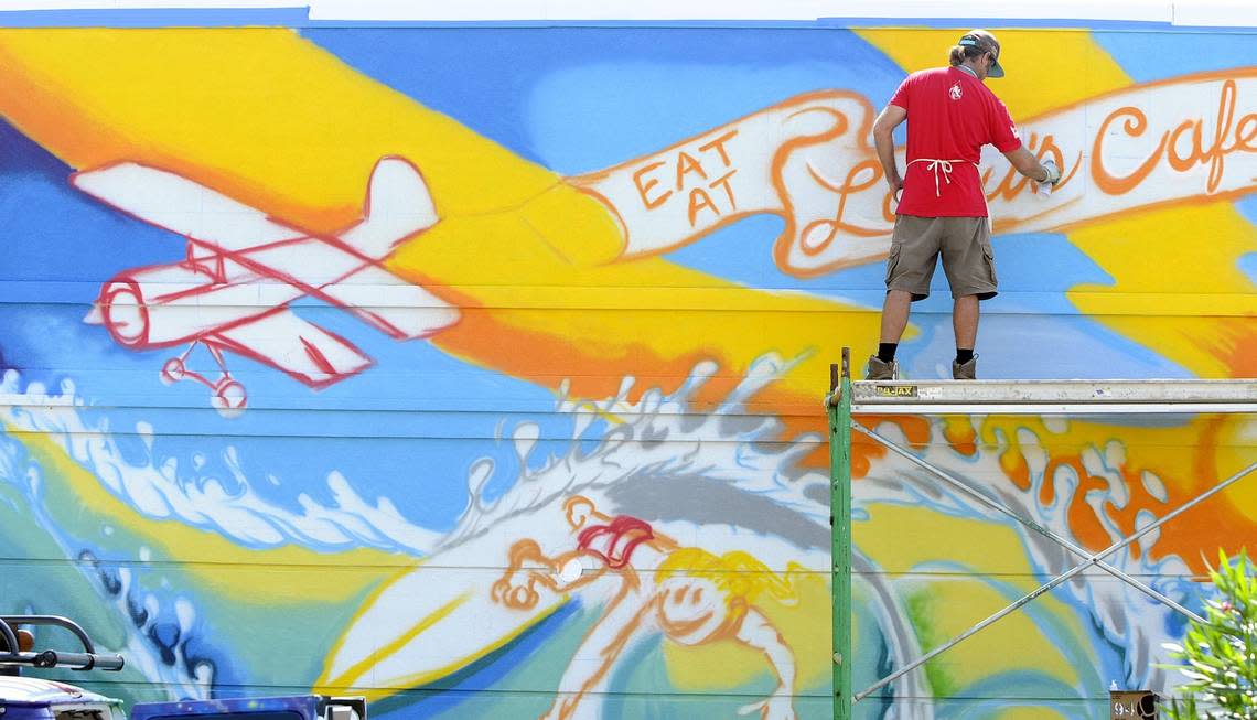 Myrtle Beach native, now living in San Clemente, CA, Drew Brophy paints a mural on the wall of Lulu’s Cafe in Myrtle Beach, Friday afternoon. The completed work, the largest he has done, will be 61x16 feet and require over 400 cans of graffiti paint to complete. 08/31/12__Photo by Charles Slate Charles Slate/cslate@thesunnews.com