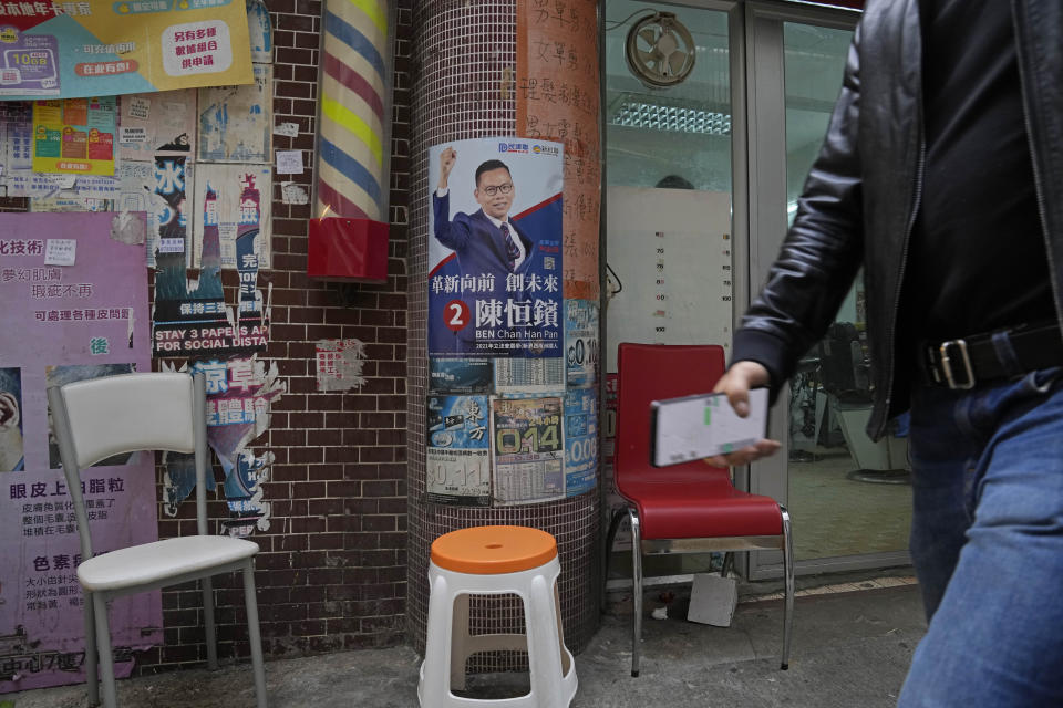 A promotional poster of legislative election candidate Ben Chan Han-pan is displayed on a wall in Hong Kong, Thursday, Dec. 16, 2021. Hong Kong voters are preparing to vote for the first time this weekend since election laws were changed, amid a dearth of opposition candidates months after the city began cracking down on dissent. The legislative elections will be held on Sunday, Dec. 19, 2021. (AP Photo/Kin Cheung)