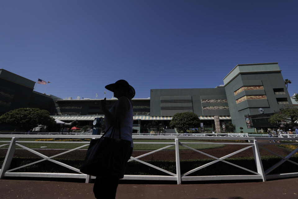 A horse racing fan waits for the fifth race near the paddock during the last day of the winter/spring meet at the Santa Anita horse racing track Sunday, June 23, 2019, in Santa Anita, Calif. (AP Photo/Chris Carlson)