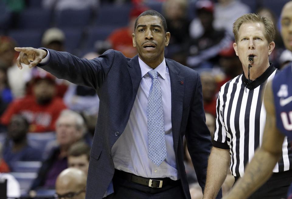 Connecticut coach Kevin Ollie gestures as he and an official watch during the second half of an NCAA college basketball game between Connecticut and Cincinnati in the semifinals of the American Athletic Conference men's tournament Friday, March 14, 2014, in Memphis, Tenn. (AP Photo/Mark Humphrey)