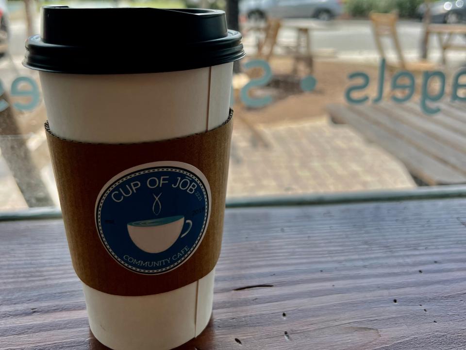 cup of coffee on a table in front of a window at a coffee shop in jacksonville beach florida