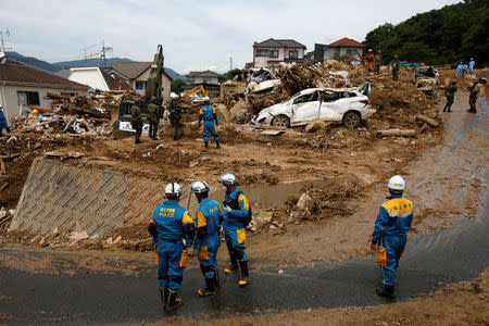 Rescue workers and Japan Self-Defense Force soldiers search for missing people at a landslide site after heavy rain in Kumano Town, Hiroshima Prefecture, western Japan, July 11, 2018. REUTERS/Issei Kato