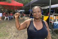 Marylis Colzin, a nurse protesting France's mandatory vaccinations for health care workers, poses in Pointe-a-Pitre, Guadeloupe island, Sunday, Nov.21, 2021. French authorities are sending police special forces to the Caribbean island of Guadeloupe, an overseas territory of France, as protests over COVID-19 restrictions erupted into rioting. In Pointe-a-Pitre, the island's largest urban area, clashes left three people injured, including a 80-year-old woman who was hit by a bullet while on her balcony. (AP Photo/Elodie Soupama)
