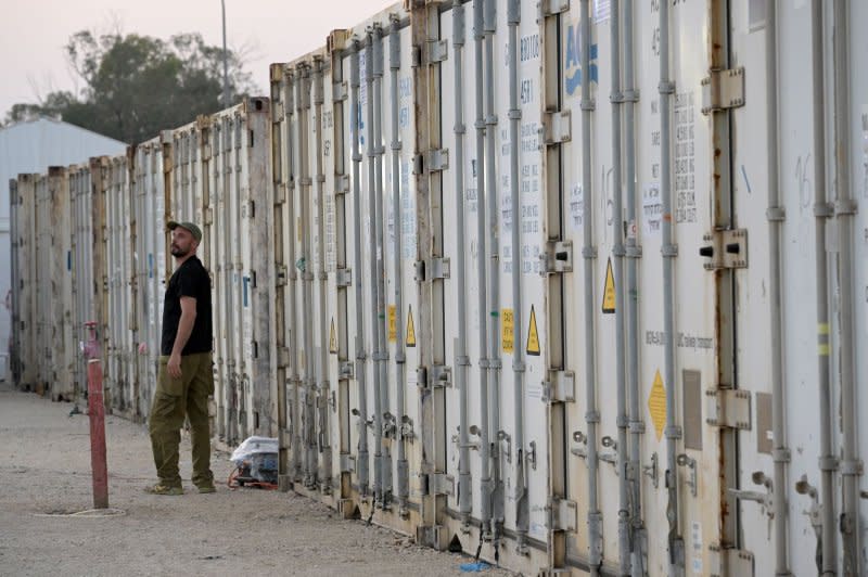 A soldier walks in front of containers full of bodies and body parts of people murdered by Hamas near the Gaza border, at the military morgue on the Shura Army Base near Ramla. Photo by Debbie Hill/UPI