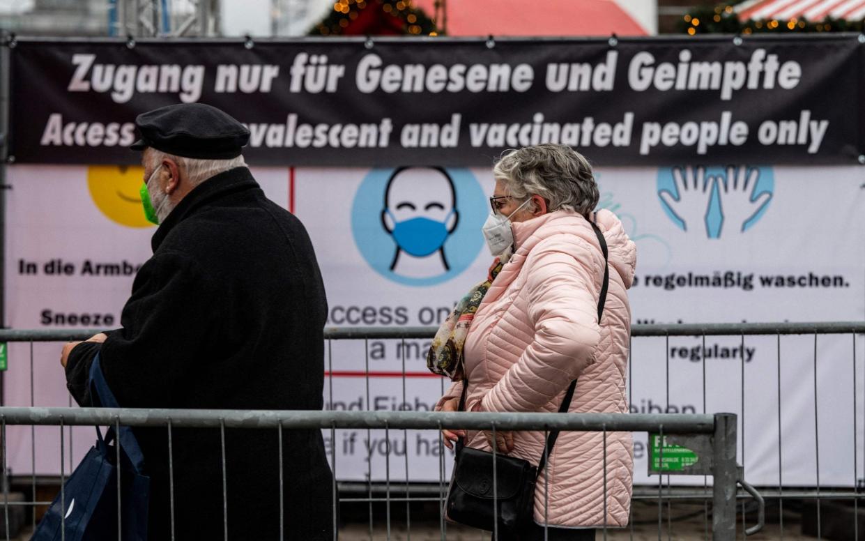 Visitors queue to enter a Christmas market in Berlin - JOHN MACDOUGALL/AFP via Getty Images