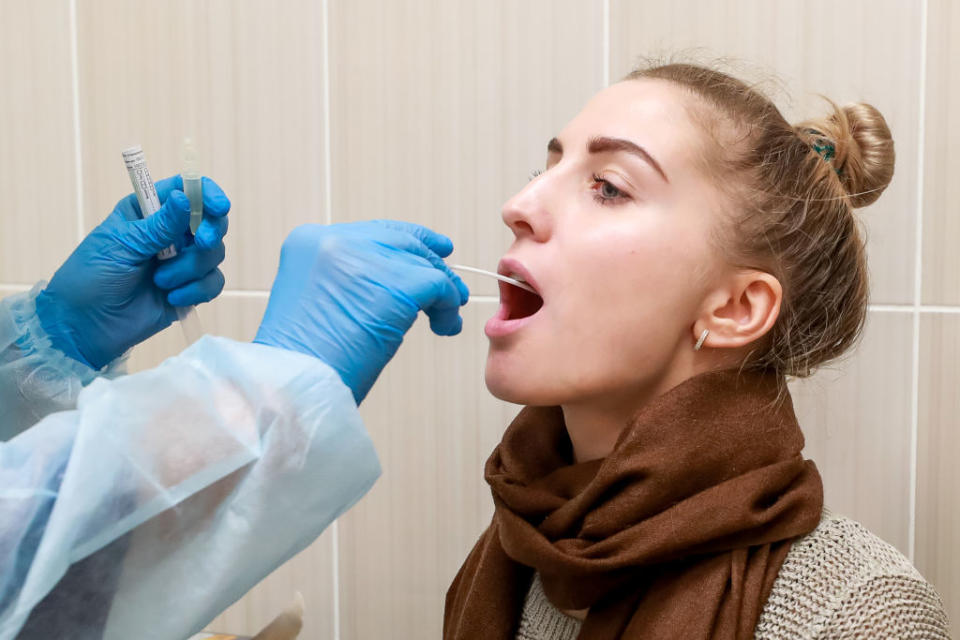 A woman has her throat swabbed at St Petersburg City Polyclinic in Russia.