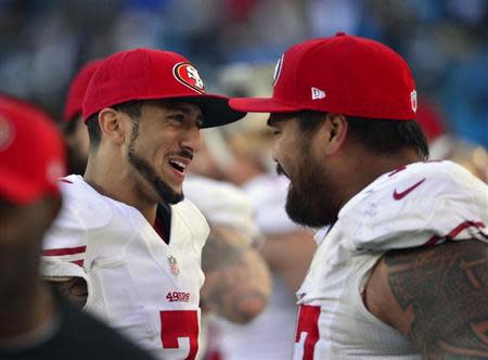 Jan 12, 2014; Charlotte, NC, USA; San Francisco 49ers quarterback Colin Kaepernick (7) and guard Mike Iupati (77) celebrate during the fourth quarter of the 2013 NFC divisional playoff football game against the Carolina Panthers at Bank of America Stadium. San Francisco won 23-10. Mandatory Credit: Bob Donnan-USA TODAY Sports